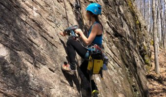 Amie Watson bolting rock climbing route in Lanaudiere Quebec