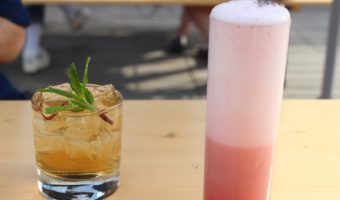 Cocktails with mint leaves and scotch and sweet fruit egg white froth on wooden picnic table