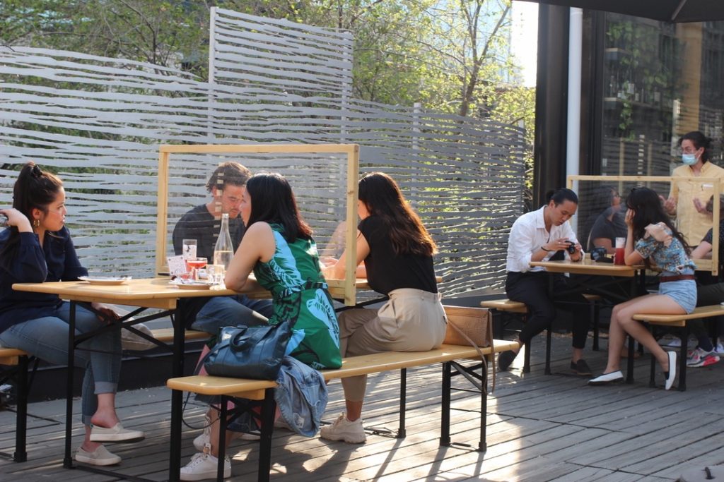 SAT terrasse with people sitting separated by pandemic screens